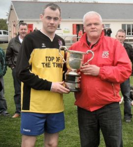 Athea Utd captain Ger Collins receives the Division 1 League Trophy from Christy Purcell, Chairman of The Limerick Desmond League at Clounreask last Sunday afternoon.  
