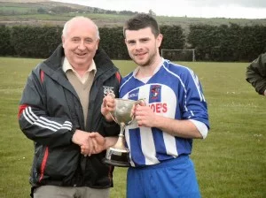 Eddie O'Shaughnessy from the Desmond League presents Pa Kiely with the Division 3 League Trophy