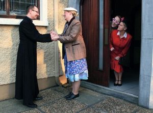 Fr McCoy (Michael  O' Connor) meeting his new parishioners under the watchful eye of local gossip Nora (Annette O'Donnell) & Cora  O’Hora (Edwina Sheehan)  
