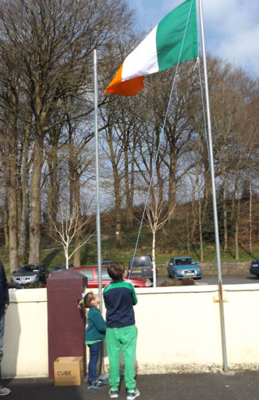 Pupils Lauren Healy and Padraig McMahon raising the flag on Proclamation Day at Athea National School 